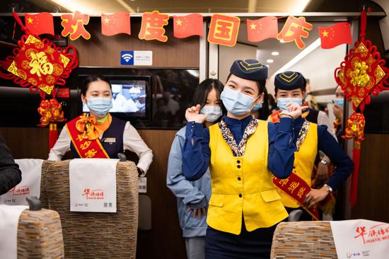 在岳阳东开往广州南的G6131次“复兴号”高铁列车上，乘务员在“喜迎国庆浓情中秋”活动中为旅客表演舞蹈（10月1日摄）。新华社记者 陈思汗 摄