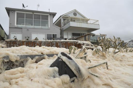 澳大利亚海滩现大量泡沫 当地居民暴雨中裸跑