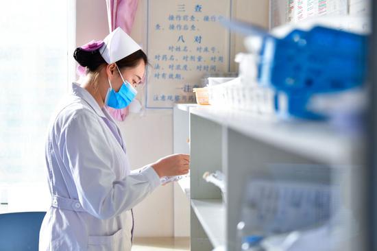 12月16日，海东市第一人民医院内科护士刘海婷在药房取药。