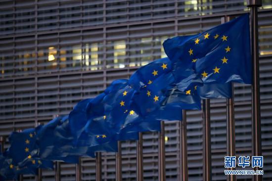 12月24日在比利时布鲁塞尔拍摄的欧盟委员会总部大楼前的欧盟旗帜。新华社记者 张铖 摄