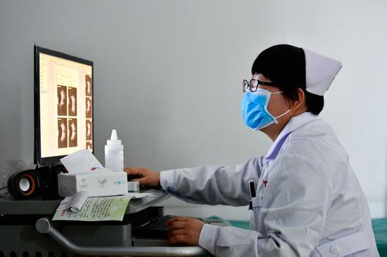 12月16日，海东市第二人民医院眼科护士许国娟在给患者检查眼睛。