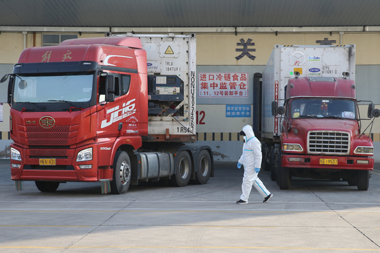 2020年12月17日，江苏省连云港市进口冷链食品集中监管仓，江苏天缘物流集团有限公司冷库场地，一名工作人员从集中监管仓装卸平台前经过。图/视觉中国