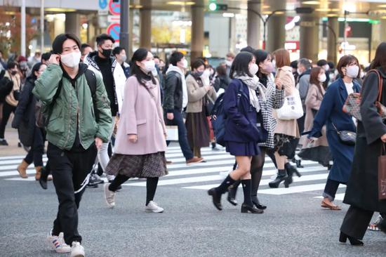 12月12日，在日本东京，人们戴口罩出行。吕天择摄