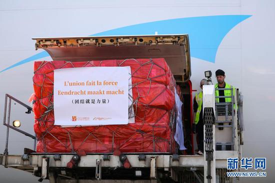 3月16日，在比利时列日机场，工作人员将口罩包裹运下飞机。来自中国的30万只口罩当地时间16日中午运抵比利时列日机场。这是欧洲新冠肺炎疫情暴发以来，比利时首次得到大规模外来援助。新华社记者 张铖 摄