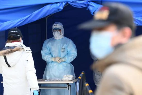 12月26日，北京市朝阳区望京街道一处采样点，工作人员即将对居民进行核酸检测采样。