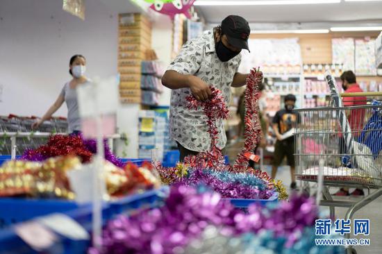 12月18日，在阿根廷布宜诺斯艾利斯，当地民众在华人商铺采购圣诞季用品。物美价优的中国商品成为许多阿根廷人的节日首选。新华社发（马丁·萨巴拉摄）