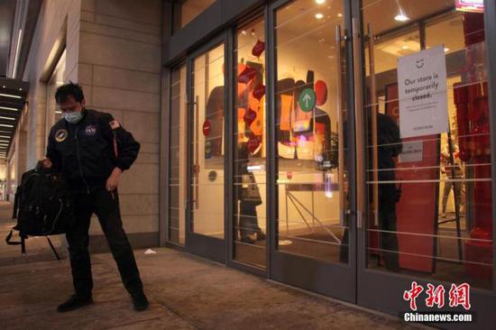 当地时间11月23日，加拿大多伦多市中心，一位男士在一家关闭的商场门外按照预约取货。 中新社记者 余瑞冬 摄