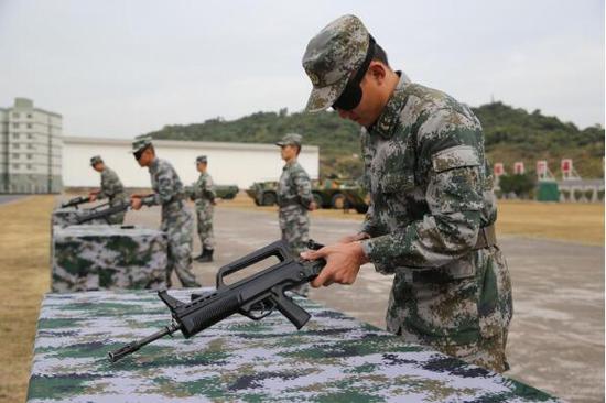  1月4日，驻澳门部队珠海基地组织官兵校场比武。这是战士们蒙眼进行轻武器分解结合。新华社发（叶华敏 摄）