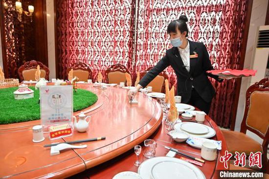 资料图:2021年1月13日,呼和浩特某酒店工作人员在餐桌上摆放公筷。刘文华 摄