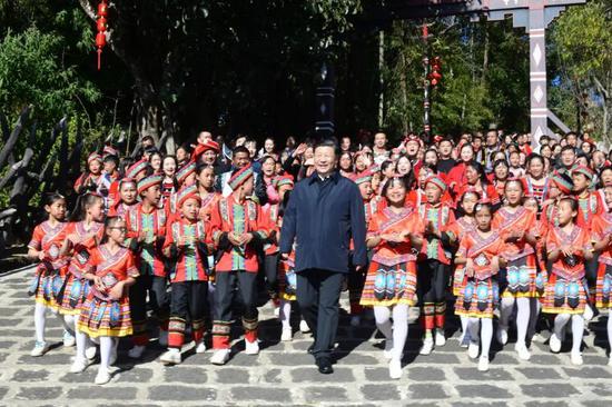 ↑2020年1月19日，云南腾冲市清水乡三家村中寨司莫拉佤族村的乡亲们唱着《阿佤人民唱新歌》，簇拥着习近平走出村口。