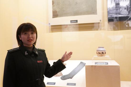 井冈山革命博物馆内讲解员龙艳正在向参观人员介绍先辈为红军“带盐”的故事。（张欢摄）