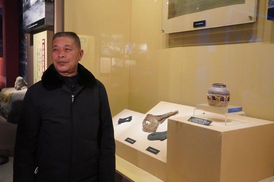 李球德在井冈山革命博物馆介绍他爷爷捐赠的盐罐（张欢摄）
