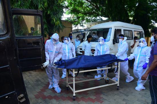  5月3日，印度医务人员在卡纳塔克邦转运新冠死亡患者的遗体。新华社 图