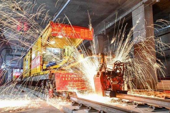 中铁十一局轨道焊机在焊接广州地铁18号线首通段最后一个钢轨接头（2021年4月20日摄）。 新华社记者 刘大伟 摄