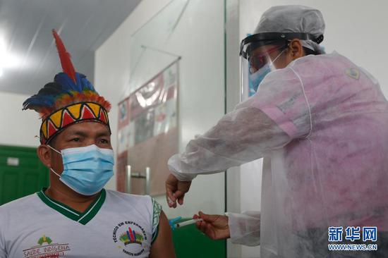 2021年1月19日，医护人员在巴西亚马孙州塔巴廷加市为一名原住民接种中国新冠疫苗。新华社发（卢西奥·塔沃拉摄）
