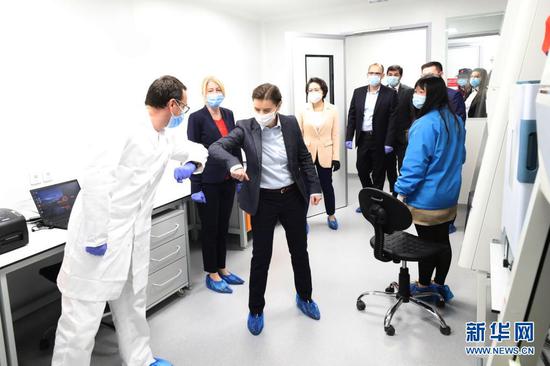 2020年4月20日，塞尔维亚总理布尔纳比奇（左三）在贝尔格莱德参观“火眼”病毒检测实验室时与一名专家“碰肘”致意。当日，由中国企业参与设计并捐赠核心设备的塞尔维亚首座“火眼”病毒检测实验室在贝尔格莱德落成。新华社发