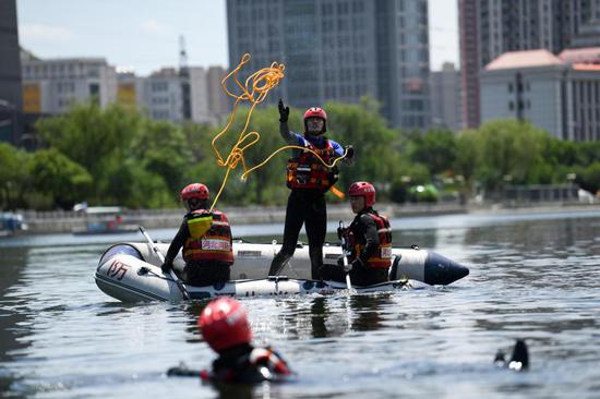 2021年6月6日，承德市消防救援支队指战员在双桥区武烈河水域进行落水人员营救演练。新华社发（王立群 摄）