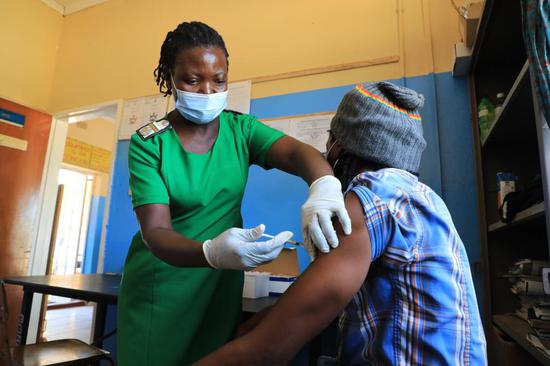 2021年2月22日，医务工作者在津巴布韦中部省戈奎的医院内为当地居民接种中国国药集团新冠疫苗。