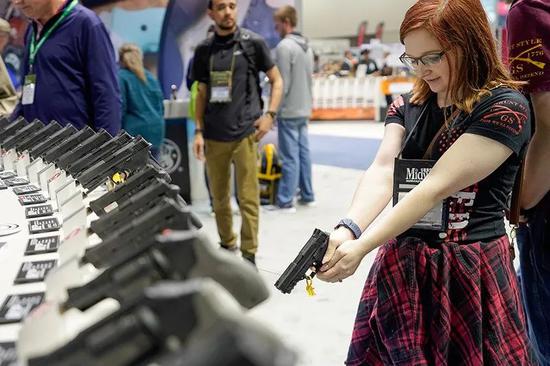  2019年4月28日，在美国印第安纳州首府印第安纳波利斯，参观者在美国全国步枪协会年会展览活动上体验手枪。