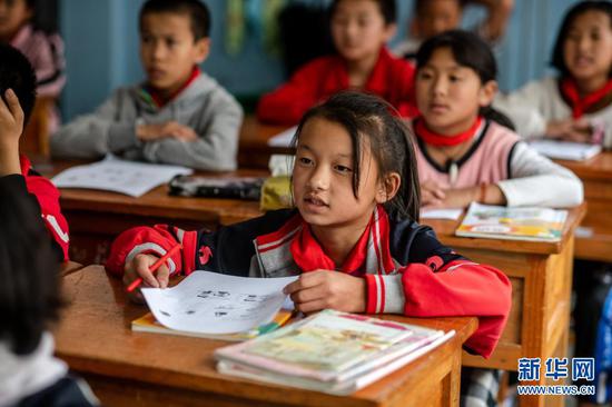  在云南贡山独龙族怒族自治县独龙江乡九年一贯制学校，独龙族学生肖琴萍在教室里上课（2020年10月31日摄）。新华社记者 江文耀 摄