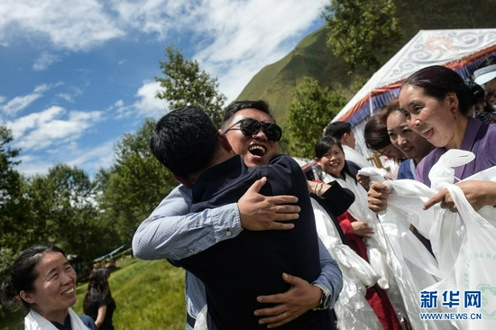 在西藏拉萨市达孜区，北京大学肿瘤医院的援藏医生袁灿（戴墨镜者）与送别的藏族同事拥抱（2020年8月1日摄）。新华社记者 彭子洋 摄