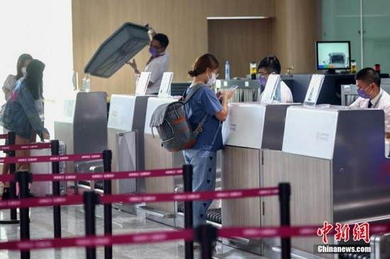 乘客在南京禄口国际机场T1候机楼内办理乘机手续。泱波 摄