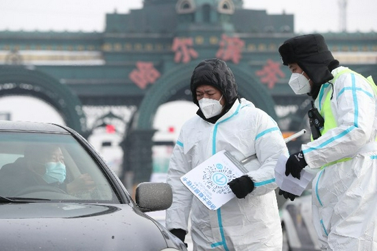 12月3日，在哈尔滨市一高速公路入城口，工作人员对入城车辆进行查验。新华社。