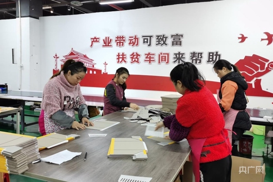 铜仁市碧江区灯塔矮屯移民搬迁安置点扶贫车间工人们正在制作包装盒（央广网发 曾江 摄）