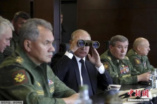 资料图：俄罗斯总统普京用望远镜观看军事演习。