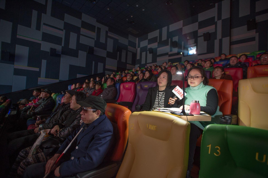△杜诚诚（第二排右一）在青山一家商业影院中，为盲人居民讲解正在放映的电影。