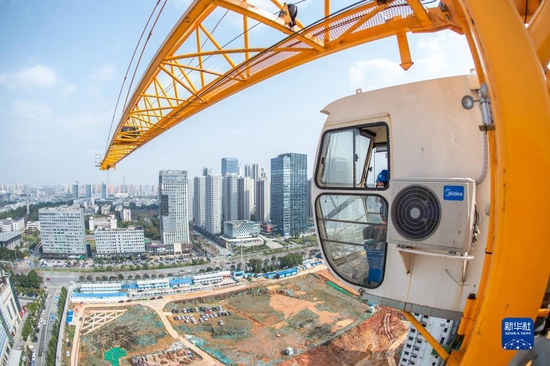 武汉市中建三局三公司的女塔吊司机张晓燕在100多米的高空中作业（2022年3月7日摄）。 新华社发（伍志尊 摄）