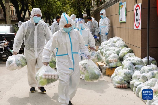 3月28日，上海市奉贤区西渡街道鸿宝一村（南区）的志愿者为居民送菜。新华社发（王燕婷 摄）