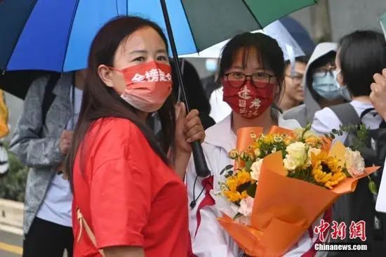 6月8日，全国部分地区2022年高考结束。图为家长戴“金榜题名”口罩在昆明市北清实验学校考点外迎接考生。中新社记者 李嘉娴 摄