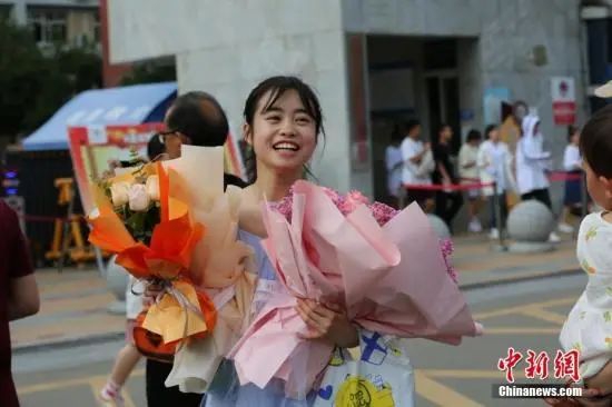6月8日，在四川眉山市东坡中学考点外，考生在考试结束后收到家长送上的鲜花。中新社发 姚永亮 摄 图片来源：CNSphoto