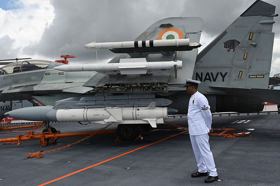 2022年9月2日，印度科钦，一名印度海军军官站在“维克兰特”号甲板上的米格-29战斗机旁边。