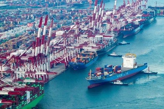 12日，青岛港前湾集装箱码头车船如织、船舶高效频靠频出。