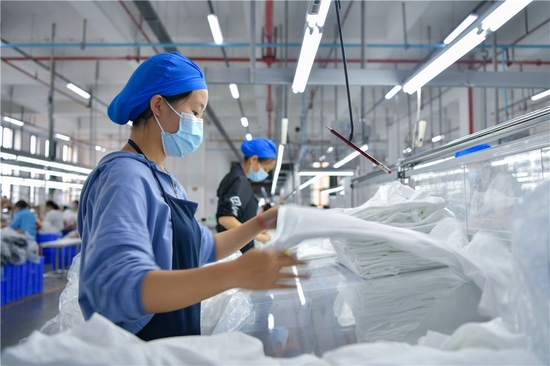 贵州省毕节市晶煌制衣有限公司的工人在赶制订单（2022年6月17日摄）。新华社发（张晓勇 摄）