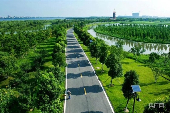 上圖：2004年的艾溪湖還是一片灘涂沼澤地，垃圾成片（央廣網(wǎng)發(fā) 南昌高新區(qū)管委會供圖）下圖：如今的艾溪湖濕地公園綠樹成蔭，芳草蘢郁（央廣網(wǎng)發(fā) 葉煉青 攝）