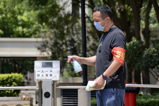 北京市大兴区旧宫镇的一名社区干部在为小区的入口设备消毒（2020年6月21日摄）。新华社记者 李欣 摄
