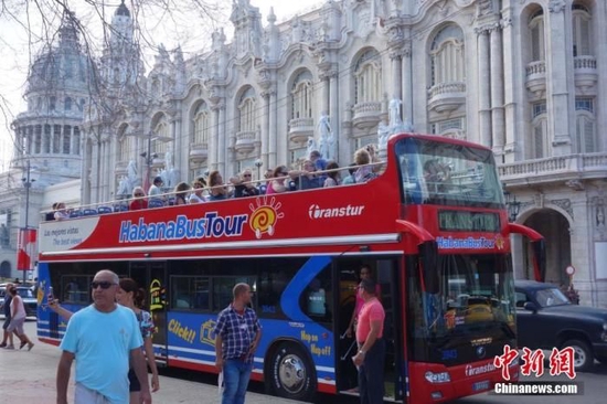  资料图：一辆旅游观光车停在古巴哈瓦那市区。中新社记者 莫成雄 摄