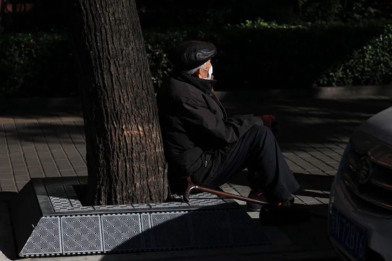 2022年10月10日，北京，疫情期间，戴口罩在路边休息的老年人。
