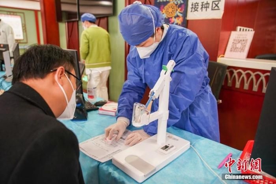 资料图:医务人员为接种者介绍疫苗信息。 陈冠言 摄