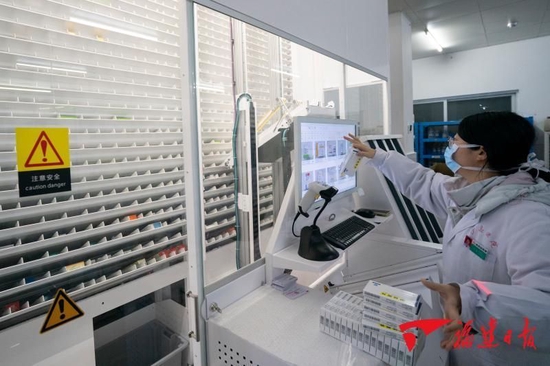 沙县总医院药房人员在通过自动化取药设备准备药品。福建日报记者王毅 摄