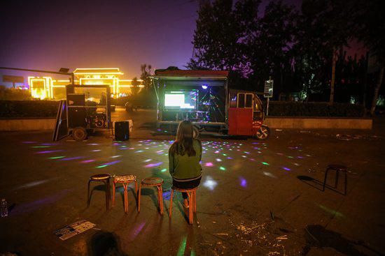 2017年9月12日晚,容城县三贤文化广场上,一名女孩在露天ktv唱歌.