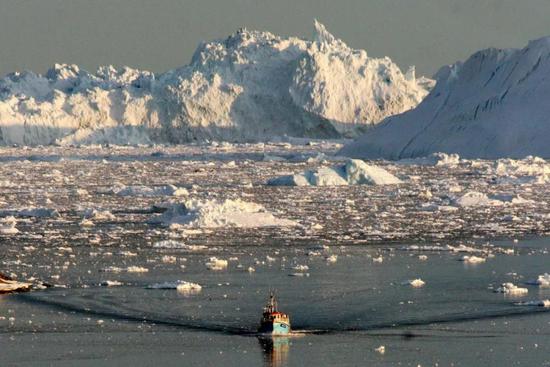  ▲资料图片：在格陵兰岛西海岸，一条船在融化的海冰中航行。（新华社）