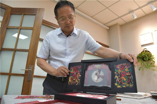 　在读者出版集团有限公司，公司副总经理富康年展示手工书《玩皮影》（8月22日摄）。新华社记者 张睿 摄