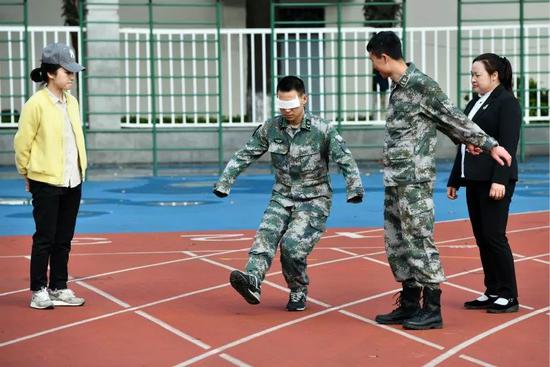 在陆军军医大学操场上，杜富国（左二）在家人和战友的陪伴下进行下肢力量康复训练。新华社记者 张永进 摄