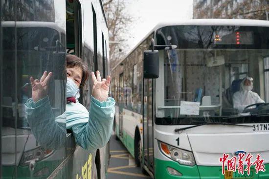 3月5日，一名新冠肺炎患者从武汉市第一医院治愈出院，登上前往隔离点的专用公交车。中青报·中青网记者李强/摄