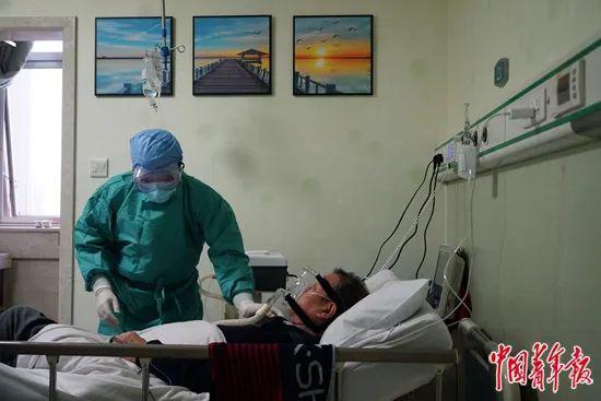 3月3日，武汉市第一医院外科大楼，呼吸内科主任罗光伟正在病房里查看病人情况。中青报·中青网记者李强/摄