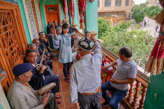 在新疆喀什古城景区的“百年茶馆”，游客和当地茶客边品茶边休闲（2020年5月17日摄）。